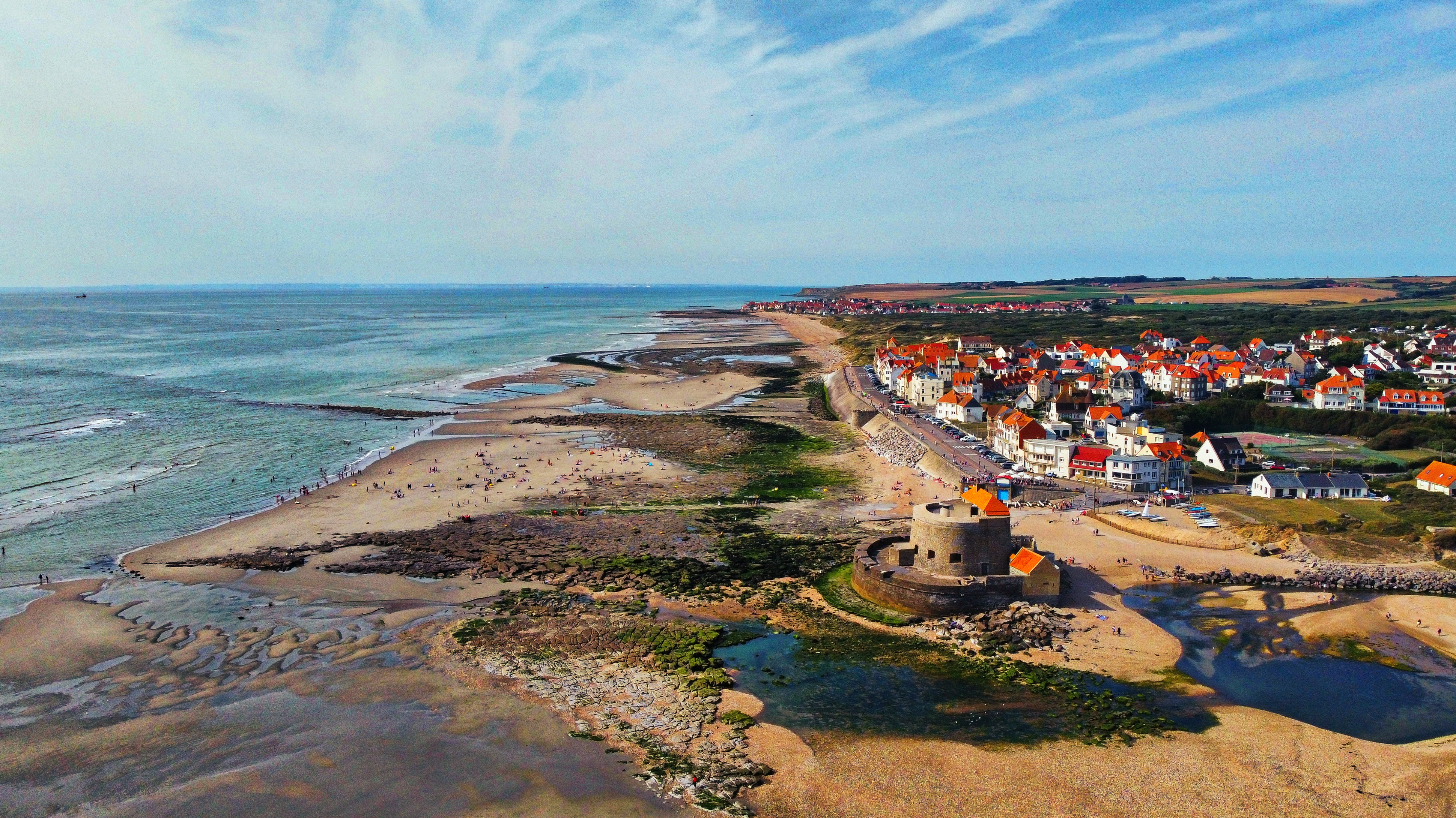 Luftaufnahme einer Küste mit Strand, Häusern und Himmel